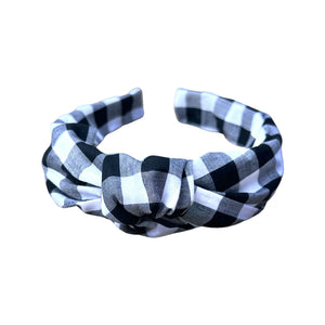 Make a statement with our Black & White Gingham Knotted Headband from SweetCityBows.com. This stylish headband features a timeless black and white gingham pattern that adds a touch of charm and versatility to any outfit. Crafted with attention to detail, it guarantees both comfort and style. Limited availability, order your Black & White Gingham Knotted Headband now and elevate your little one's look!